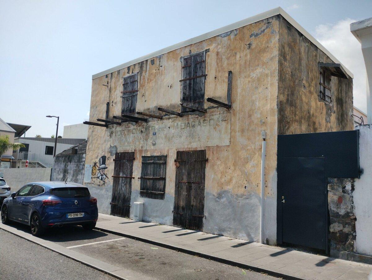 Antiguo edificio del Crédito hipotecario de Madagascar en el Puerto, fachada envejecida y arte urbano