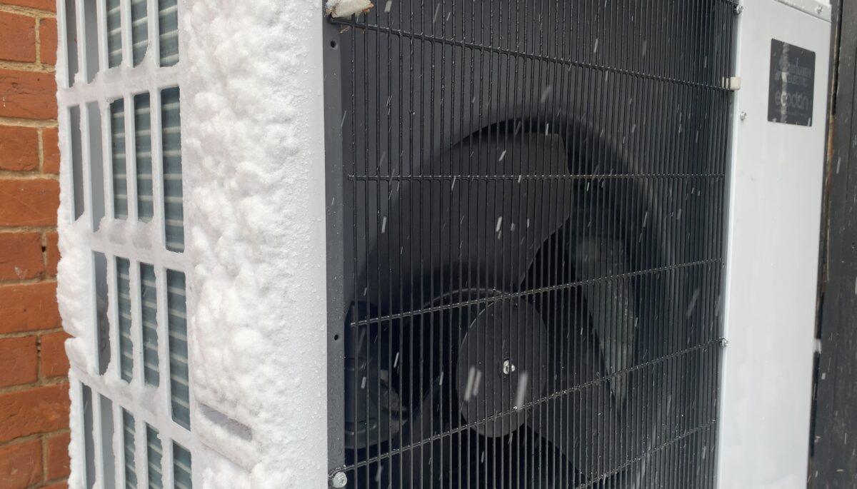 Außeneinheit der Luft-Wasser-Wärmepumpe Mitsubishi Ecodan im Betrieb im Schnee