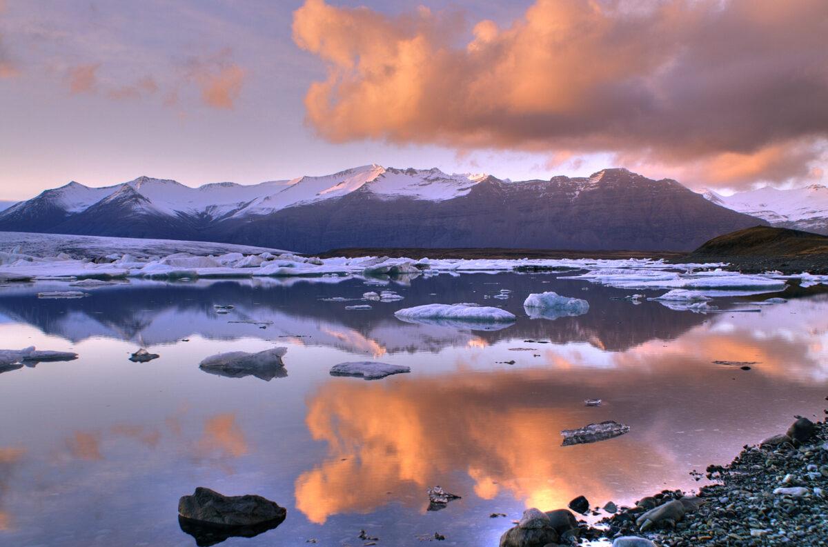 Jökulsárlón : lagune glaciaire au coucher de soleil avec montagnes et icebergs