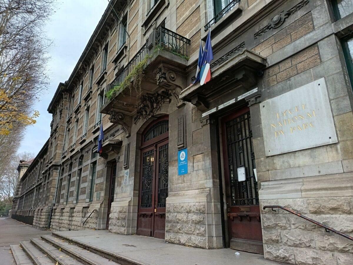 Façade and entrance of Lycée du Parc in Lyon, blond stone and flags