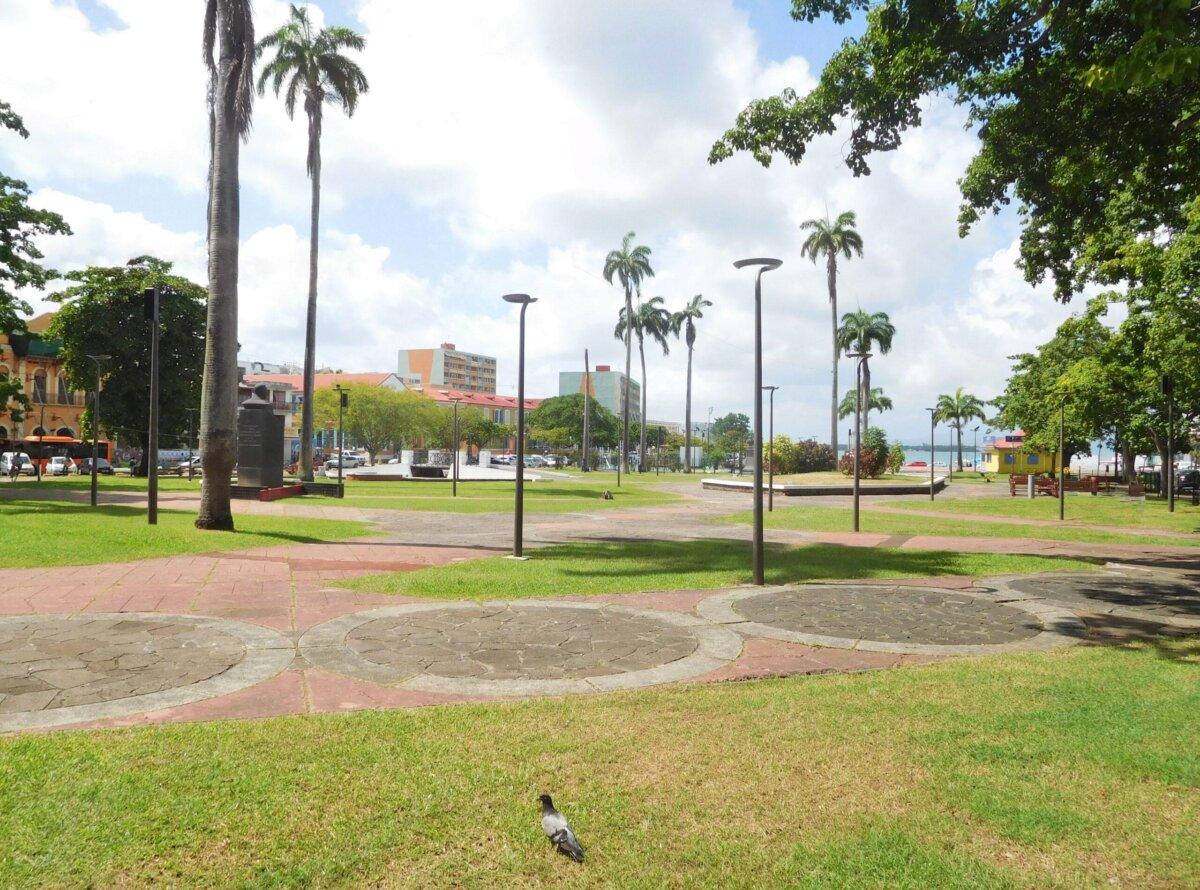Plaza de la Victoria en Pointe-à-Pitre, céspedes, palmeras y frente construido