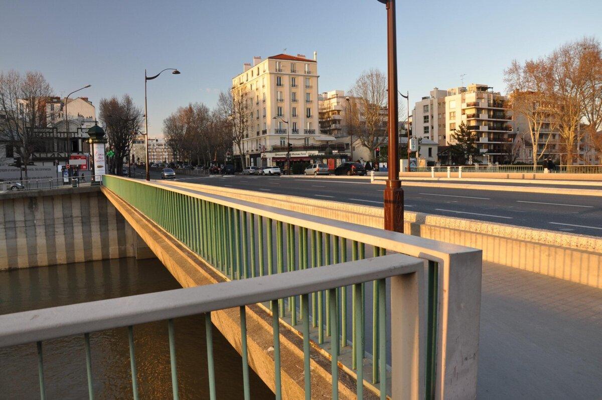 Puente de Courbevoie al atardecer, barandillas verdes sobre el Sena