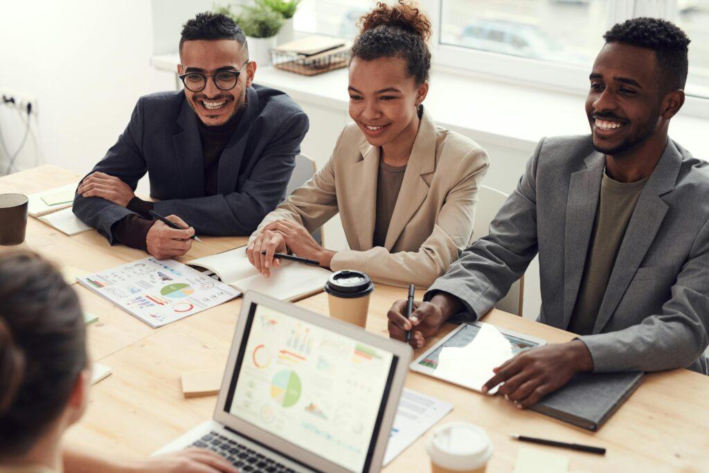 Equipo de trabajo feliz colaborando alrededor de una mesa
