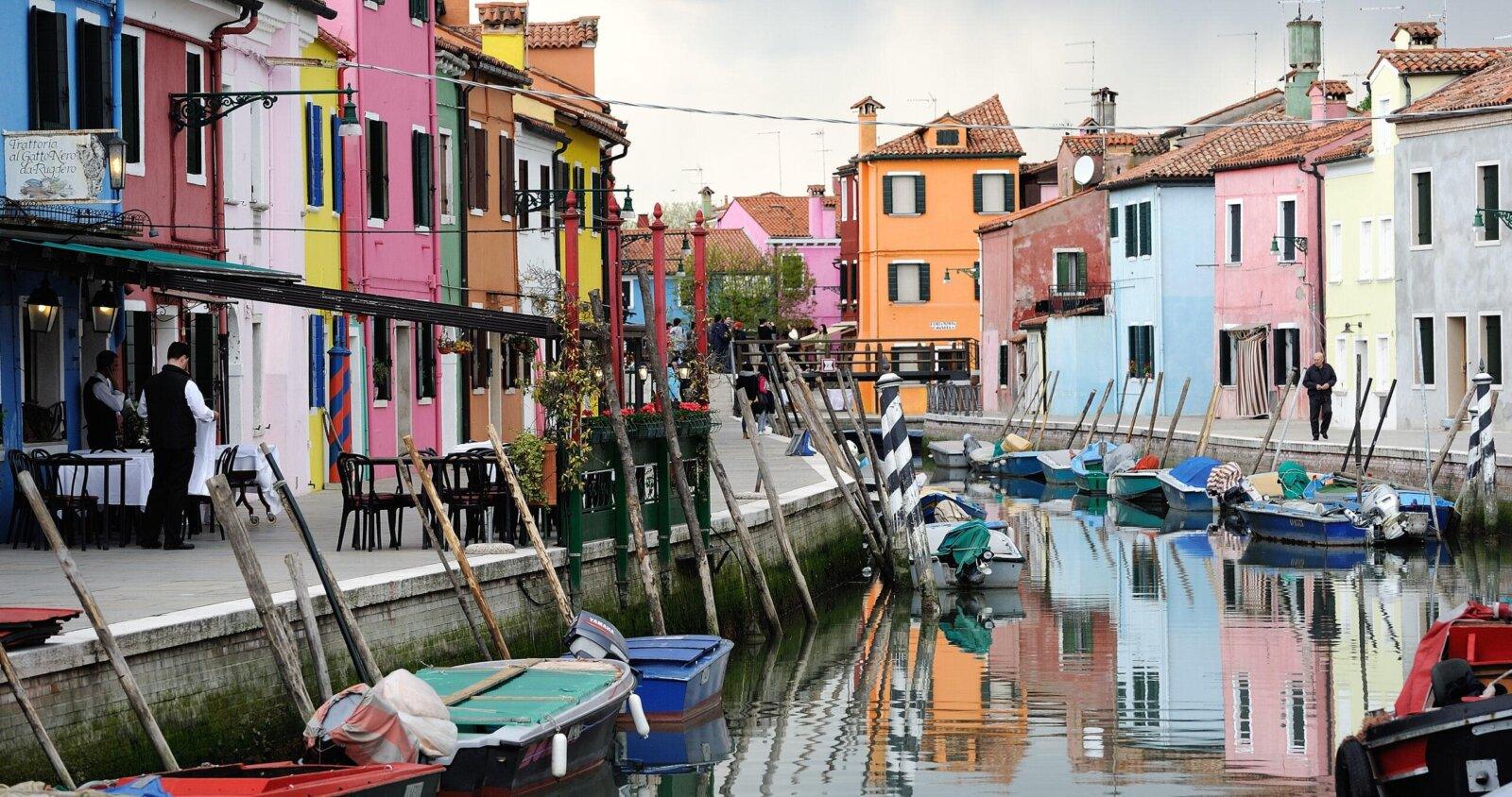 Colorful houses of Burano along the canal, moored boats