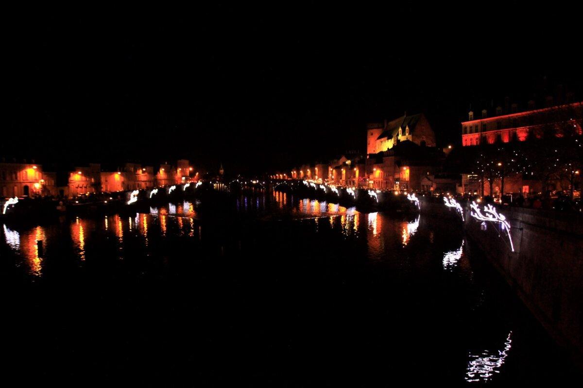 Beleuchtungen der Lichter von Laval, die sich nachts in der Mayenne spiegeln