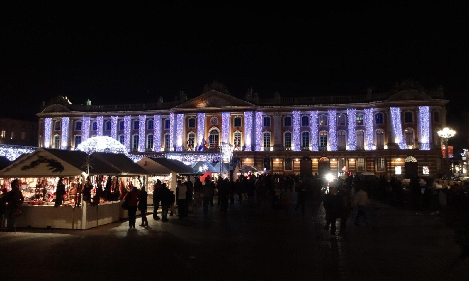 Marché de Noël Toulouse place Capitole façade rose chalets blancs illuminés midi