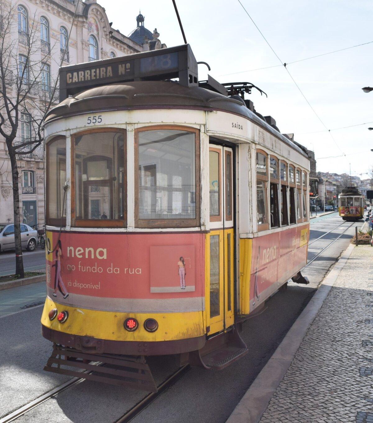 Yellow tram 28 running through the streets of Lisbon