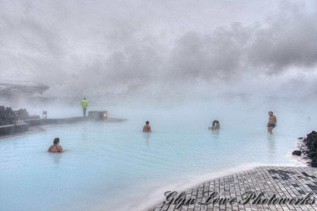 Personnes se baignant dans les eaux laiteuses du Blue Lagoon en Islande l’hiver