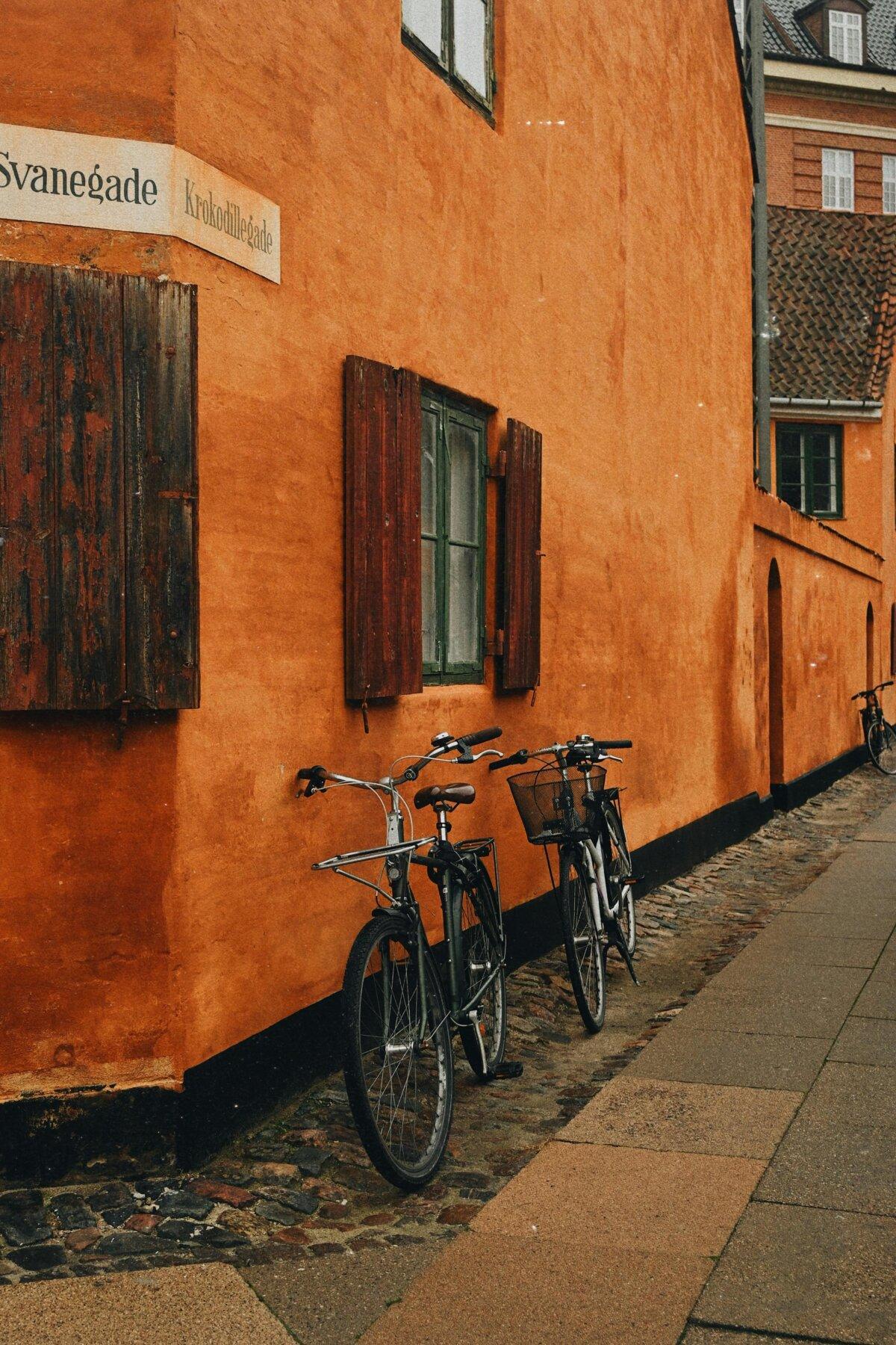 Rue de Copenhague avec façades orange et vélos appuyés au mur