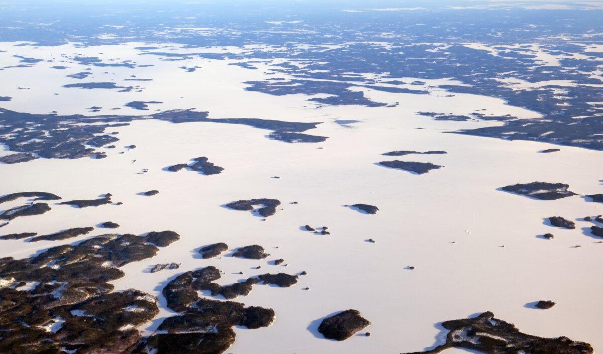 Winterliche Luftaufnahme des zugefrorenen Saimaa-Sees und schneebedeckter Inselchen in Finnland