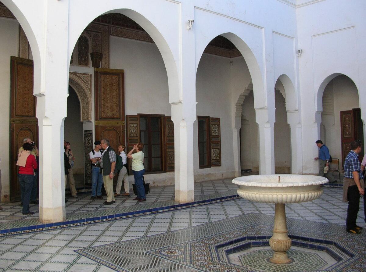 Cour intérieure du palais de la Bahia à Marrakech avec arcades blanches et fontaine