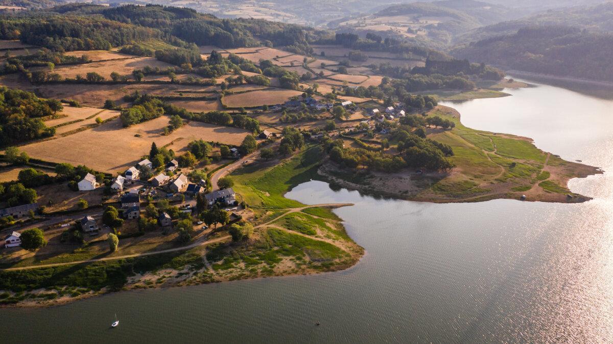 Vista aérea de un camping junto a un lago en Francia, paisaje ondulado