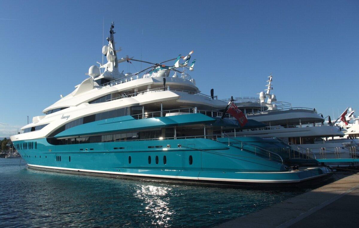 Große türkise Motoryacht, die in einem Hafen vertäut ist