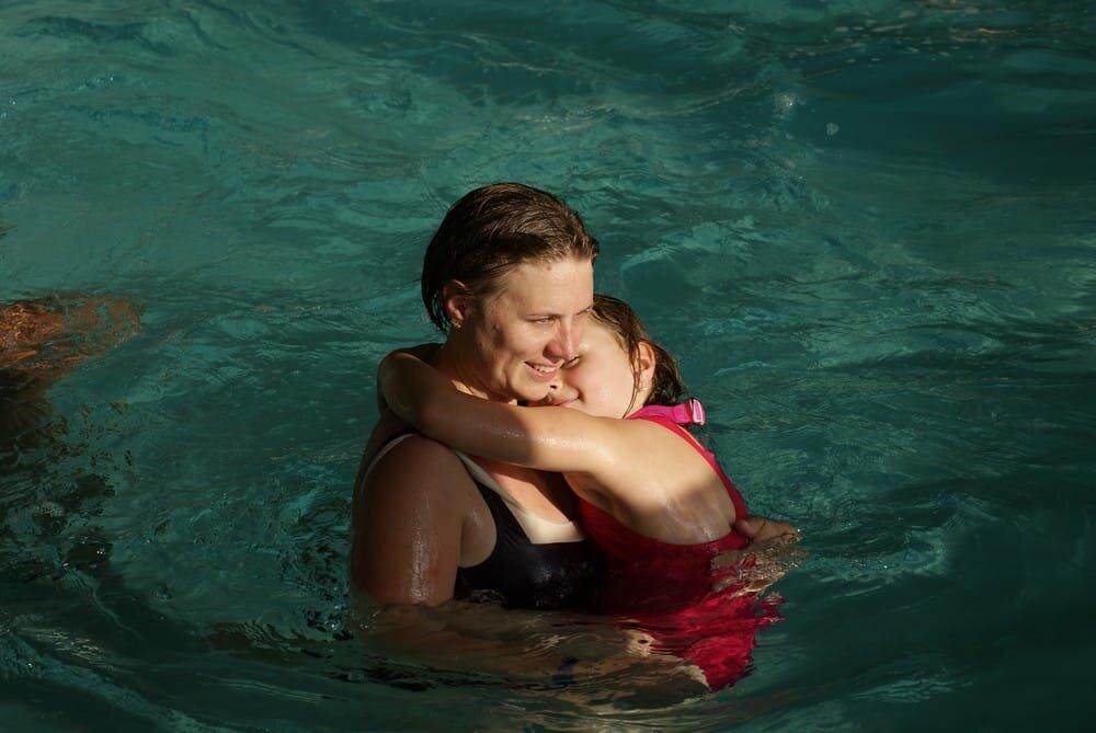 Moment de détente entre un parent et un enfant dans une piscine couverte