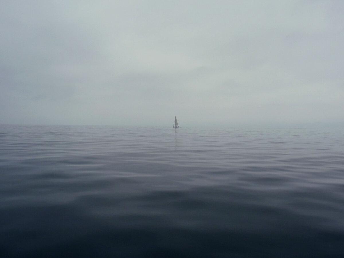 Kleines Segelboot isoliert auf einem ruhigen Meer