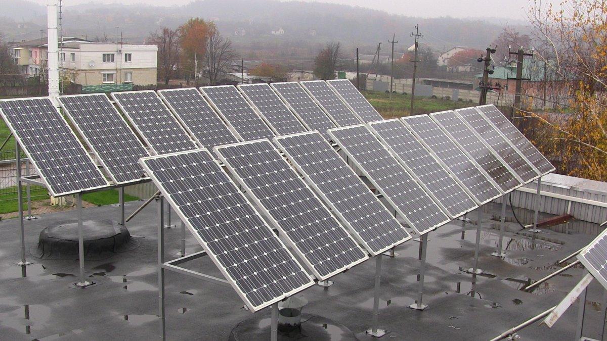 Filas de paneles fotovoltaicos inclinados sobre un techo plano