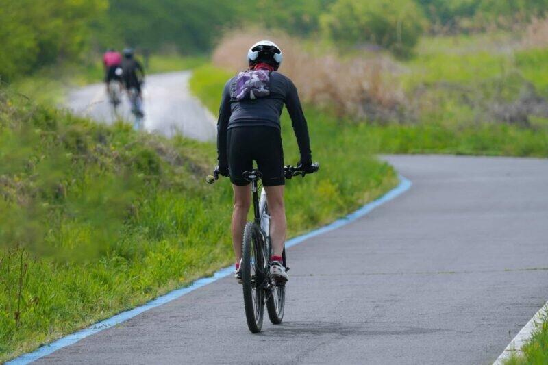 Cyclistes sur une route de campagne propice aux balades dans un séjour en Normandie