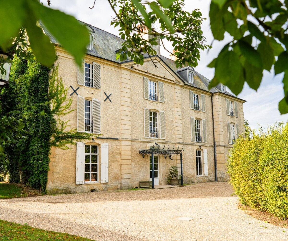 Façade du manoir du Domaine de Bois Roger dans un environnement arboré en Normandie