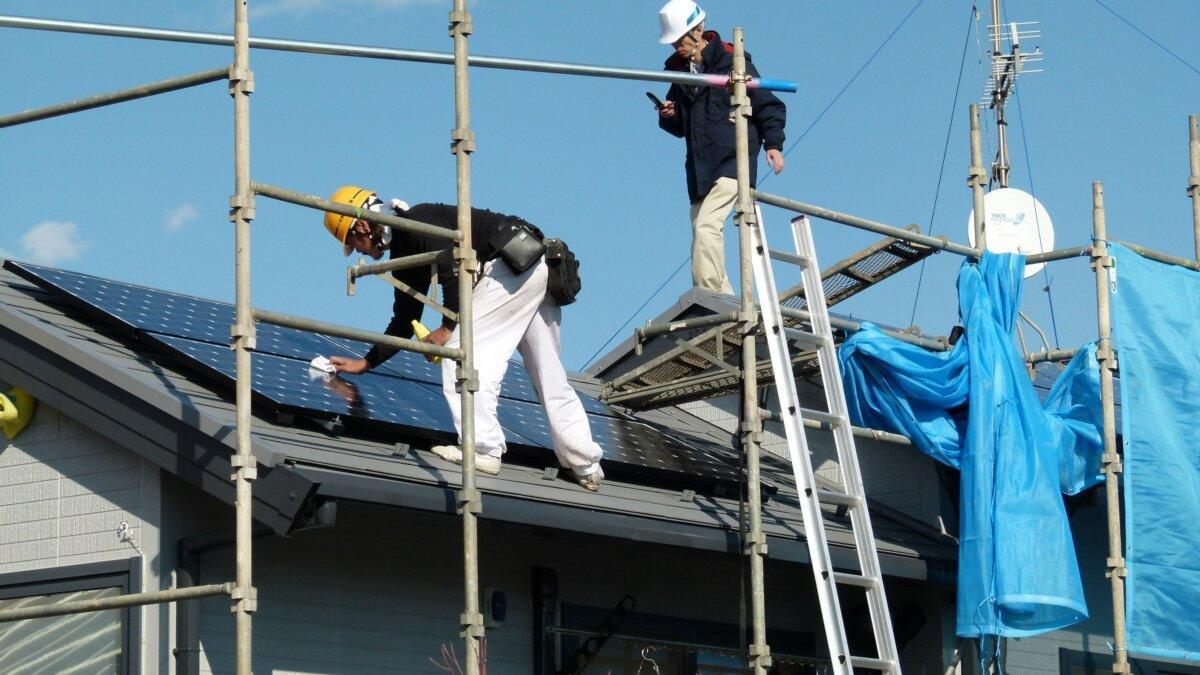 Técnico limpiando paneles fotovoltaicos en un techo